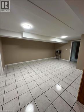 Hamilton apartment for rent - A spacious room with a white tile floor and a small refrigerator.