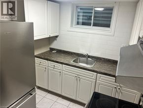 Hamilton apartment for rent - A kitchen with white cabinets and a stainless steel refrigerator.