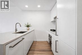 Burnaby apartment for rent - A modern kitchen with white cabinets and a wooden floor.