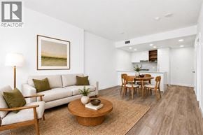 Burnaby apartment for rent - A living room with a white couch, a coffee table, and a painting on the wall.