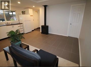 Coquitlam apartment for rent - A living room with a black couch and a plant on a table.