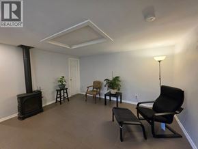 Coquitlam apartment for rent - A living room with a wood stove and a black chair.