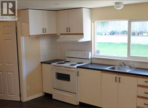 Coquitlam apartment for rent - A kitchen with white cabinets and a black countertop.