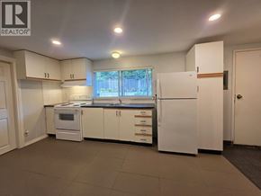 Coquitlam apartment for rent - A kitchen with white appliances and cabinets is for sale.