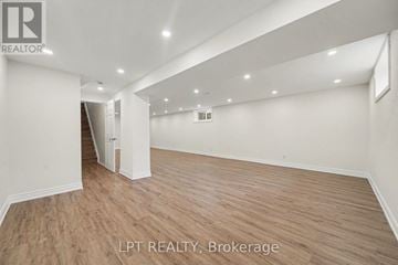 Ottawa apartment for rent - A spacious room with wooden flooring and white walls, with a logo that reads "REALTOR" in the top left corner.