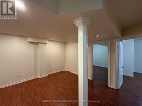 Brampton (Northwest Brampton) apartment for rent - A room with wooden floors and white walls, with a column in the middle.