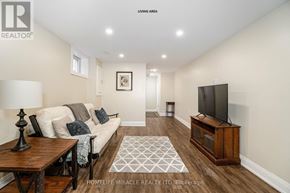 Brampton (Brampton North) apartment for rent - A living room with a couch, a coffee table, a rug, and a television.