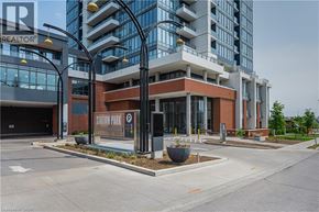 Kitchener condo for rent - A modern building with a glass facade and a sign that reads " Station Park".