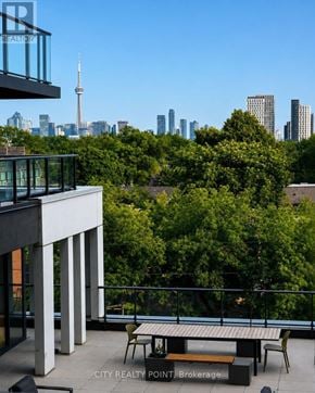 Toronto (Annex) condo for rent - A balcony with a table and chairs overlooking a city skyline.