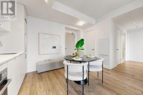 Toronto (Waterfront Communities) condo for rent - A modern kitchen with a dining table set for two.