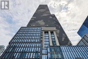 Toronto (Waterfront Communities) condo for rent - A tall building with a triangular top and a logo of a realtor on the bottom left.