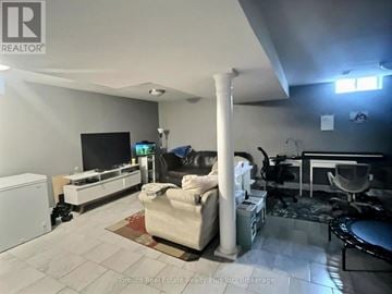 New Tecumseth (Alliston) apartment for rent - A living room with a white couch and a television.