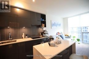 Toronto (Annex) condo for rent - A modern kitchen with a white countertop and dark cabinets.