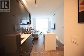 Toronto (Annex) condo for rent - A modern kitchen with a large island in the middle.