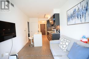 Toronto (Annex) condo for rent - A living room with a white couch and a television on the wall.