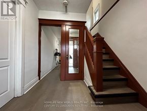 Hamilton (Westdale) apartment for rent - A hallway with a staircase and a door leading to another room.