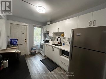 Hamilton (Westdale) apartment for rent - A kitchen with white cabinets and a stainless steel refrigerator.