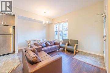 Waterloo townhouse for rent - A living room with a brown couch and a white chair.