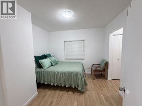 Vancouver apartment for rent - A bedroom with a bed, chair, and window.