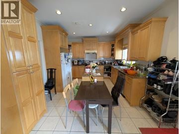 Vancouver apartment for rent - A kitchen with wooden cabinets and a table with chairs.
