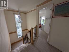 Vancouver apartment for rent - A hallway with a staircase and a chandelier.