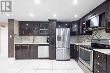 Toronto (Kingsview Village-The Westway) condo for rent - A modern kitchen with dark brown cabinets and stainless steel appliances.