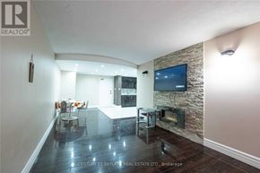 Toronto (Kingsview Village-The Westway) condo for rent - A living room with a stone wall and a flat screen TV.