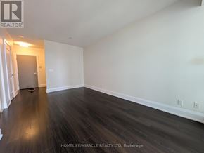 Toronto (High Park-Swansea) condo for rent - A room with wooden flooring and white walls.
