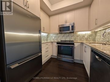 Toronto (High Park-Swansea) condo for rent - A kitchen with a stainless steel refrigerator and a microwave above the stove.