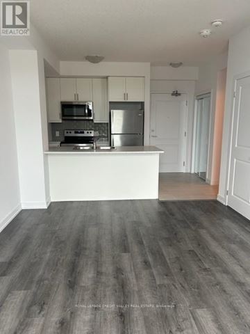 Hamilton (Waterdown) condo for rent - A kitchen with white cabinets and a wooden floor.