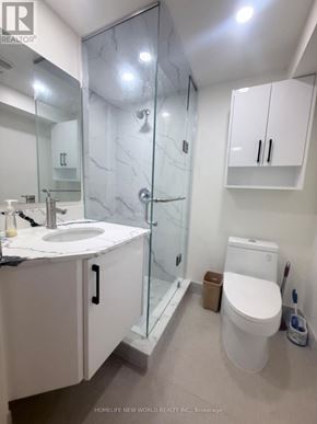 Toronto (Hillcrest Village) apartment for rent - A white sink and toilet in a bathroom with a glass shower door.