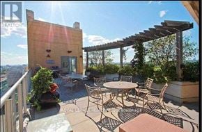 Toronto (University) condo for rent - A patio with a table and chairs overlooking a cityscape.