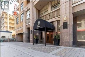 Toronto (University) condo for rent - The image shows a building entrance with a black awning and the number 438 on it.