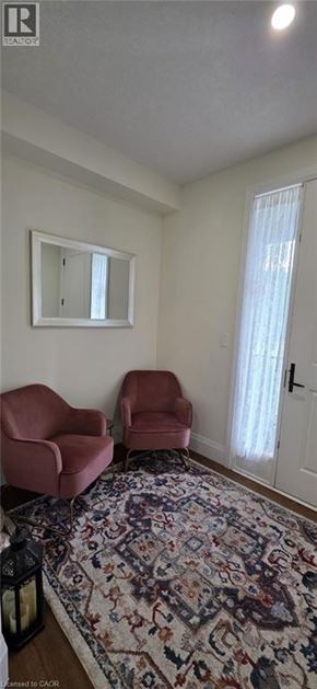 Ayr apartment for rent - Two red chairs are placed in a room with a large rug.
