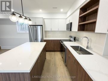 Toronto (Danforth Village-East York) apartment for rent - A modern kitchen with wooden cabinets and a white countertop.
