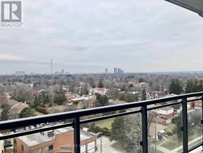 Toronto (Bayview Woods-Steeles) condo for rent - A view from a balcony overlooking a residential area with a distant city skyline.