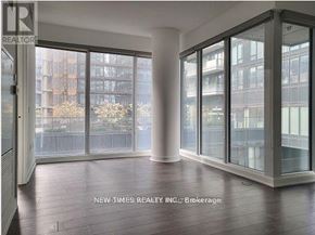 Toronto (Waterfront Communities) condo for rent - A room with a view of a cityscape through large windows.