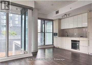 Toronto (Waterfront Communities) condo for rent - A spacious kitchen with white cabinets and a large window.