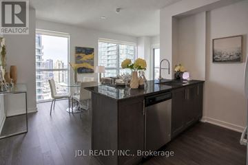 Mississauga (City Centre) condo for rent - A modern kitchen with dark wood floors and a large island.