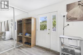 Fort Erie (Central) multi-family for rent - A room with a white door, a mirror, a shelf with shoes, and a lamp.