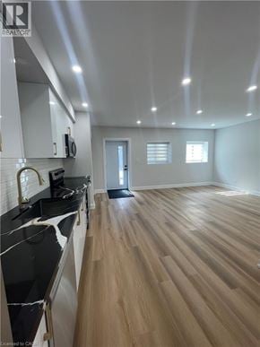 Kitchener apartment for rent - A kitchen with black countertops and wooden floors.