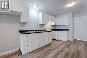 North Stormont apartment for rent - A kitchen with white cabinets and a black countertop.