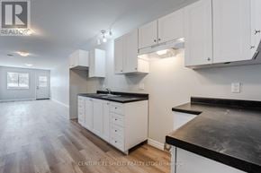 North Stormont apartment for rent - A real estate listing image of a kitchen with white cabinets and black countertops.