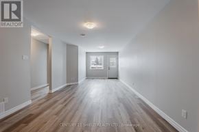North Stormont apartment for rent - A spacious room with wooden flooring and white walls, featuring a large mirror and a framed picture on the wall.