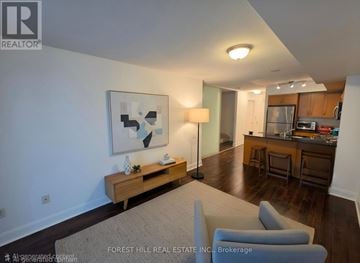 Toronto (Mount Pleasant West) condo for rent - A living room with a couch, a table, and a painting on the wall.