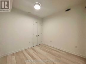 Toronto (Waterfront Communities) condo for rent - A room with a wooden floor and a white wall with a door.