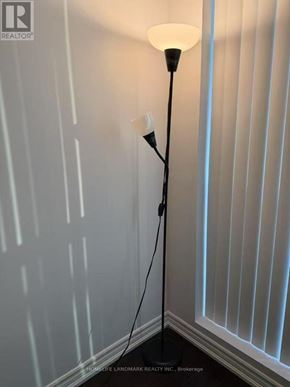 Toronto (Bay Street Corridor) condo for rent - A floor lamp with a white shade stands in a corner of a room.