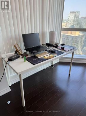Toronto (Bay Street Corridor) condo for rent - A laptop and a tablet are on a desk in front of a window with blinds.