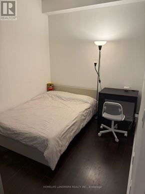 Toronto (Bay Street Corridor) condo for rent - A bedroom with a bed, chair, and lamp.