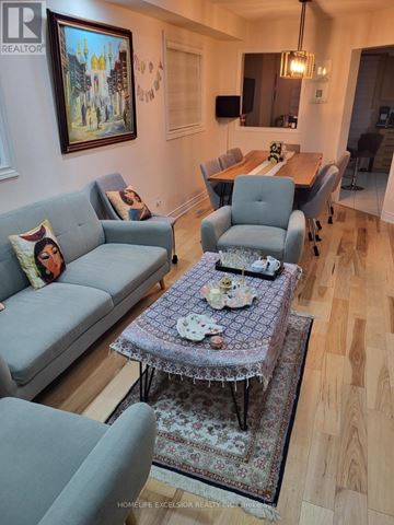 Mississauga (Churchill Meadows) apartment for rent - A living room with a grey couch and a table with a purple tablecloth.